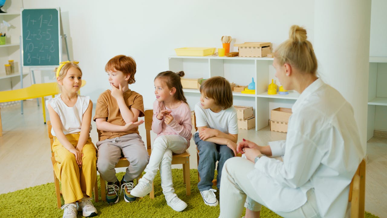 A group of children interacting in a classroom with their teacher, fostering learning and social skills.