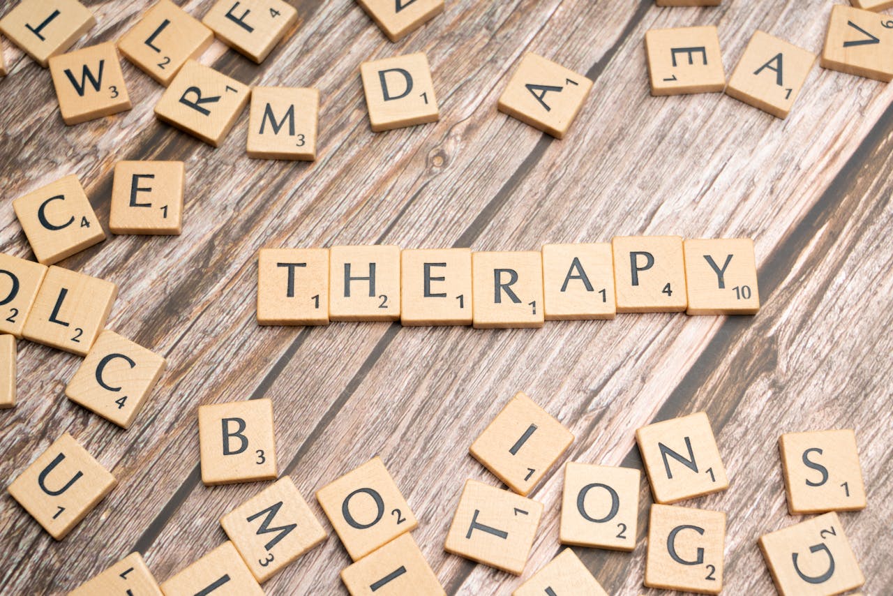 The Art of Drawing Readers In: Your attractive post title goes here Wooden letter tiles spelling therapy on a wooden background, emphasizing mental health.